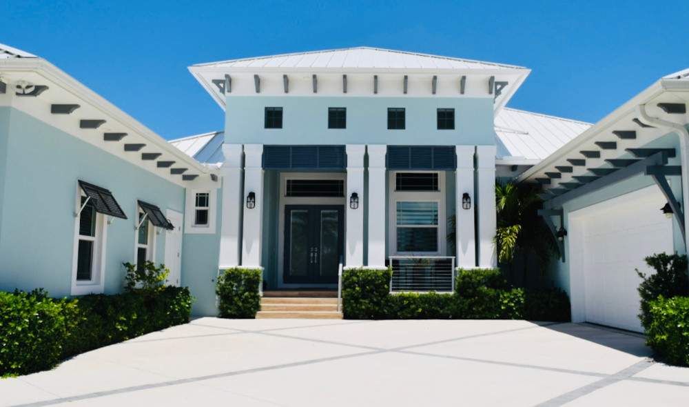 Light blue house with dark blue bahama shutters and white trim
