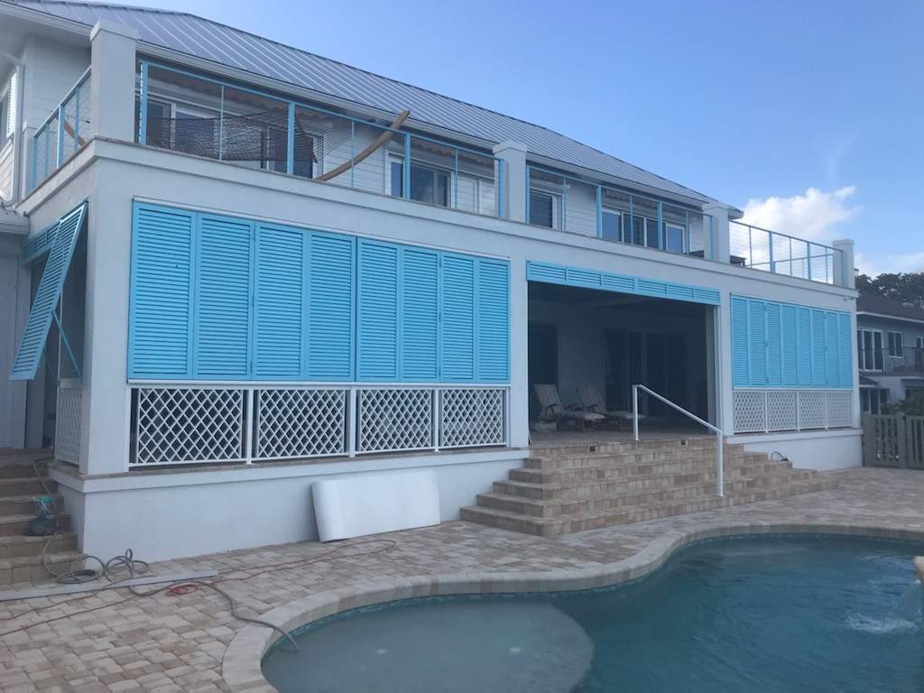 Aqua blue bahama shutters closed on the pool deck