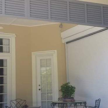 Dark Gray Roll Down Shutters on Porch with Patio Table