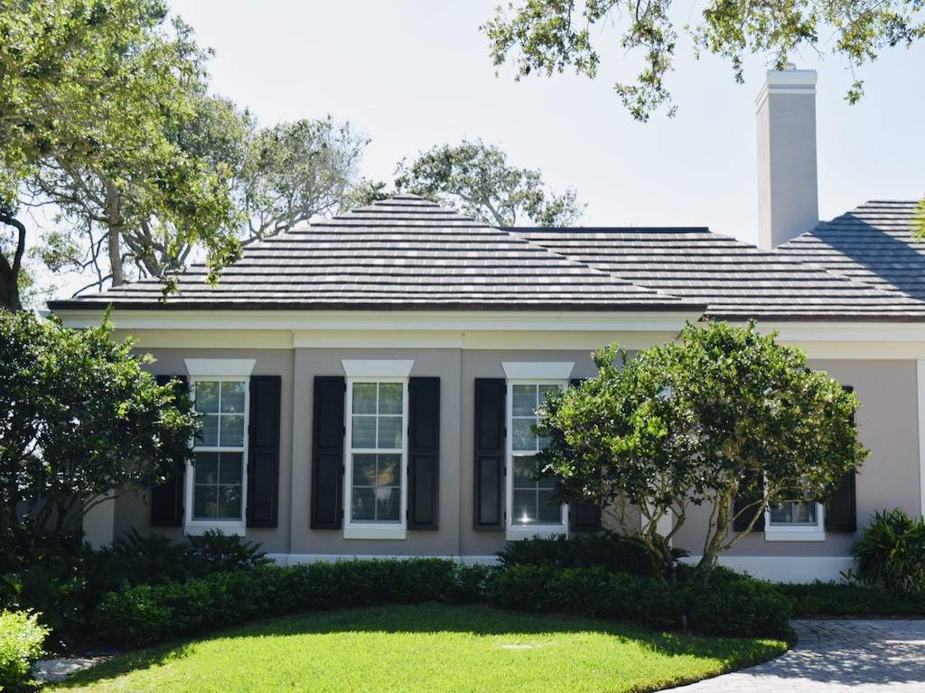 black colonial shutters on a gray house with tall windows